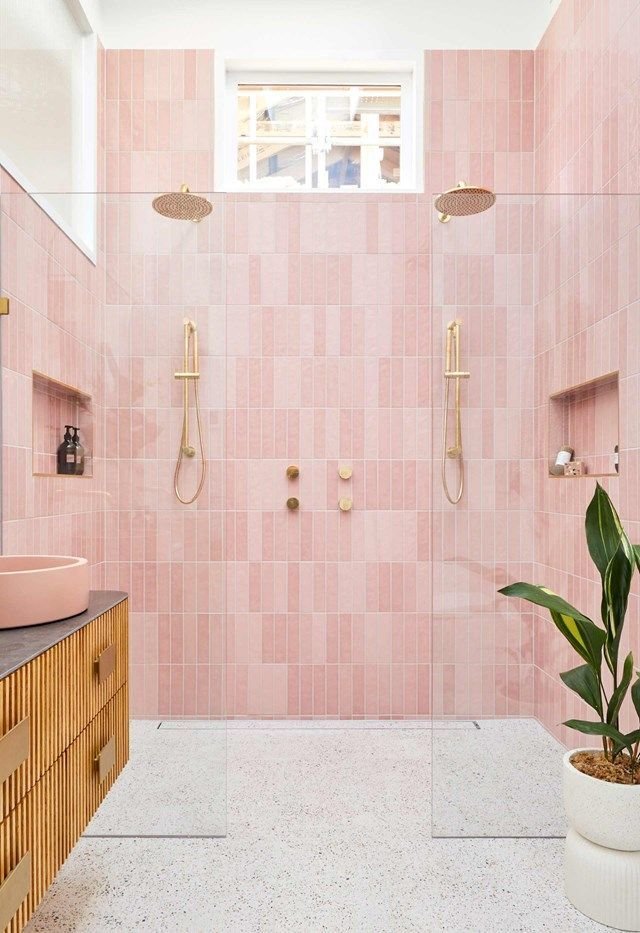 Pink tiled bathroom with brass shower fittings and terrazzo floor