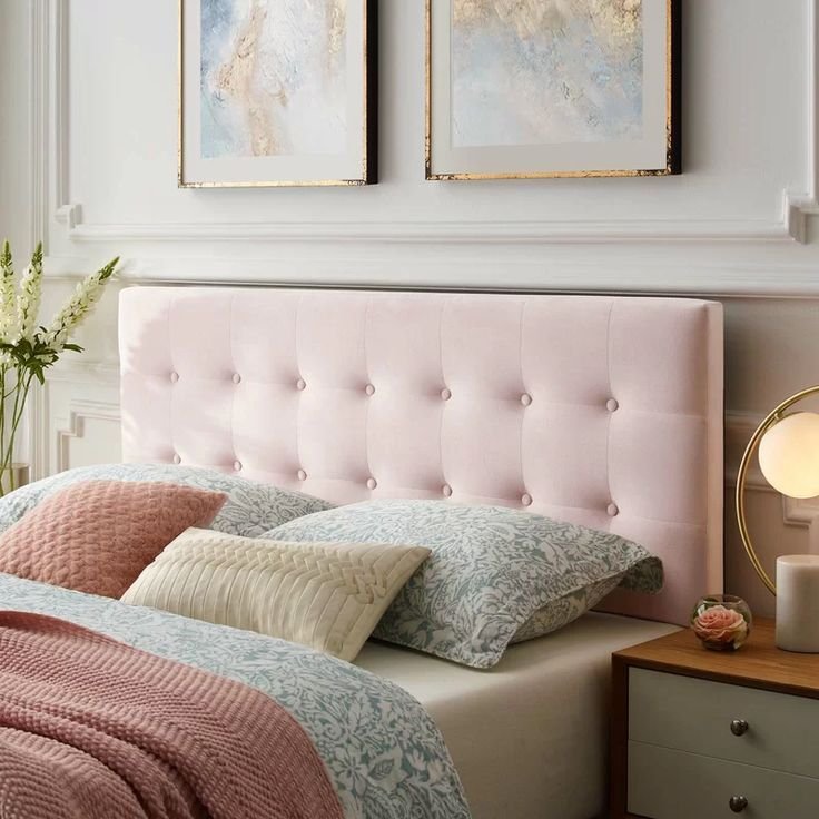Soft pink upholstered headboard with neutral bedding in a bedroom