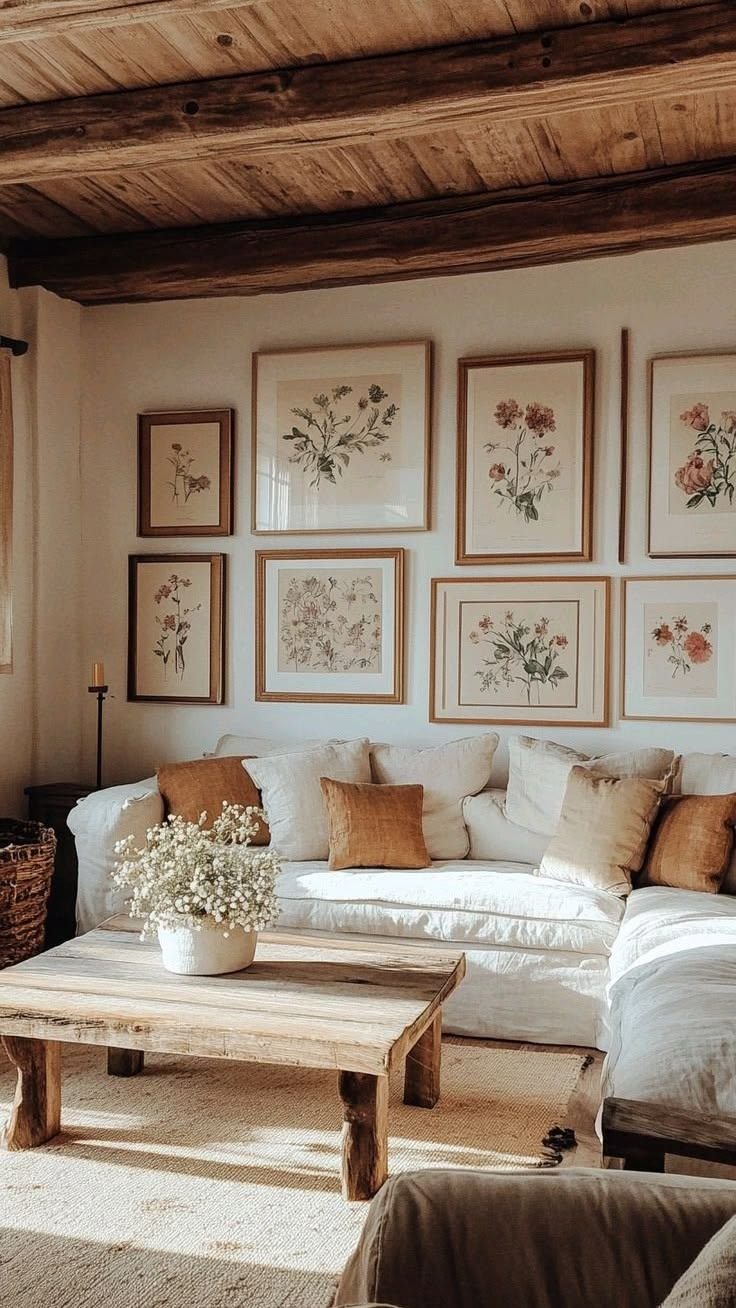 Rustic living room with exposed wood beams, a linen sofa and framed botanical prints in cottagecore style