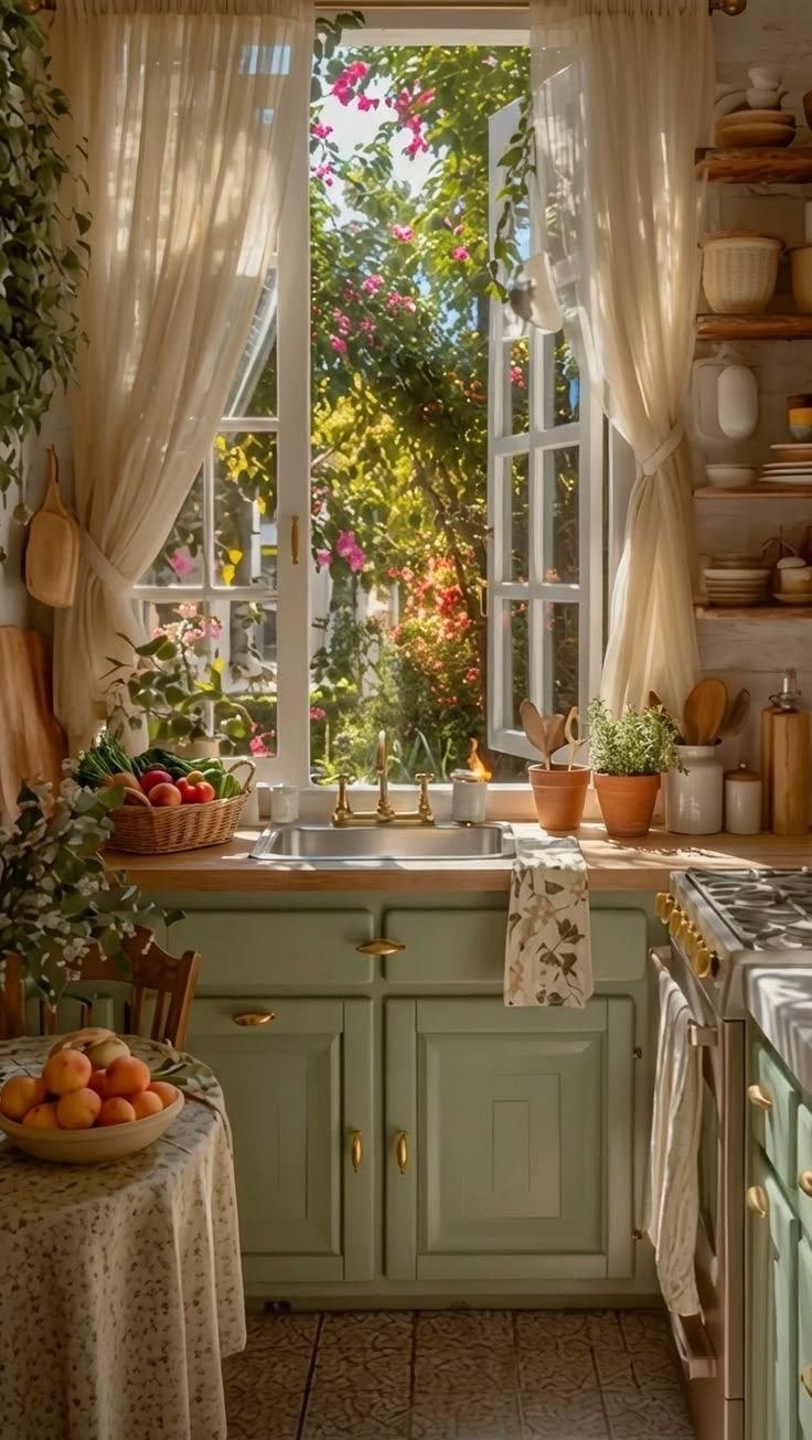 Sage green cottage kitchen with an open window above the sink, potted herbs and a flowering garden outside