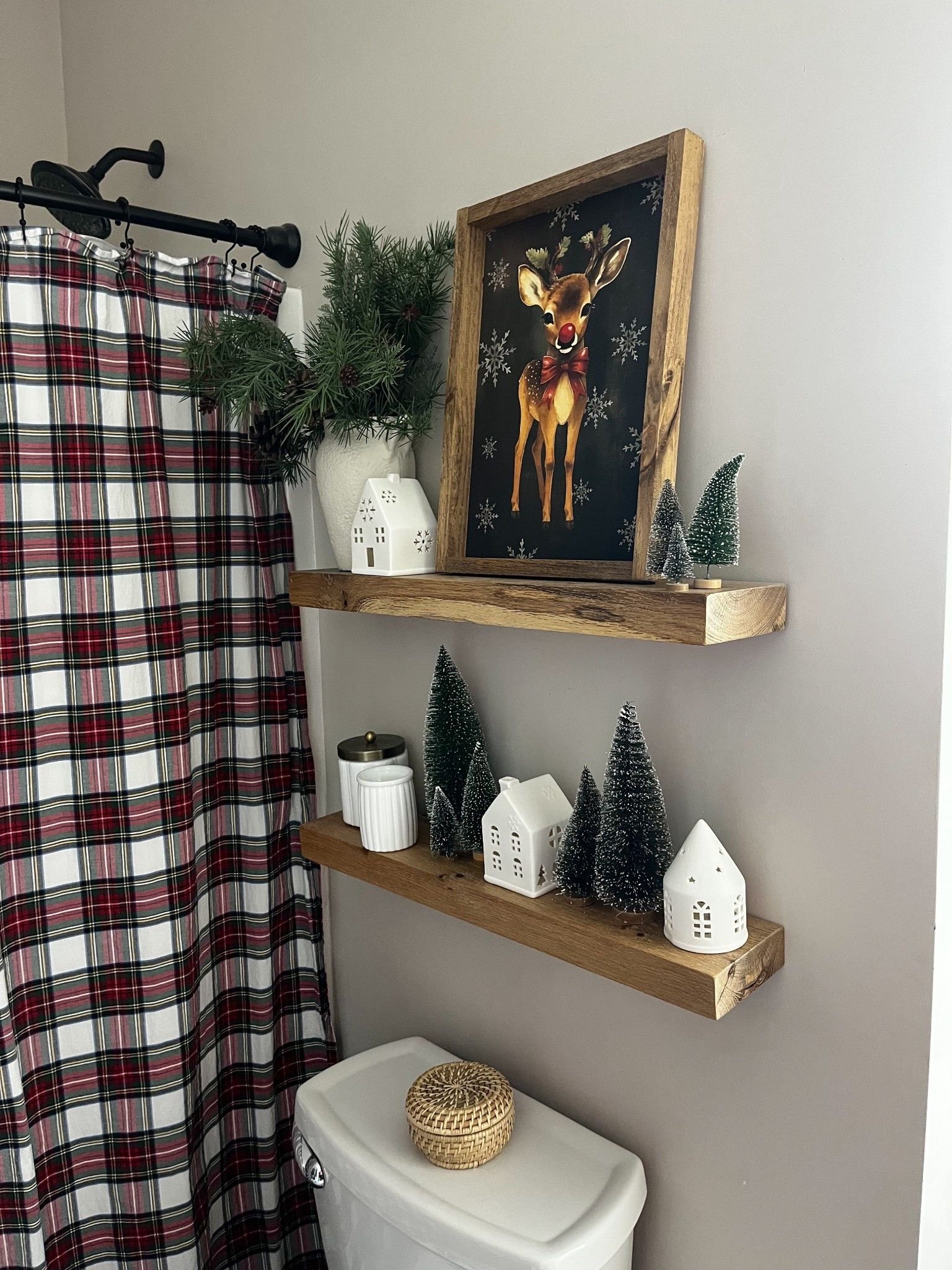Floating shelves with a reindeer art print and small white Christmas houses