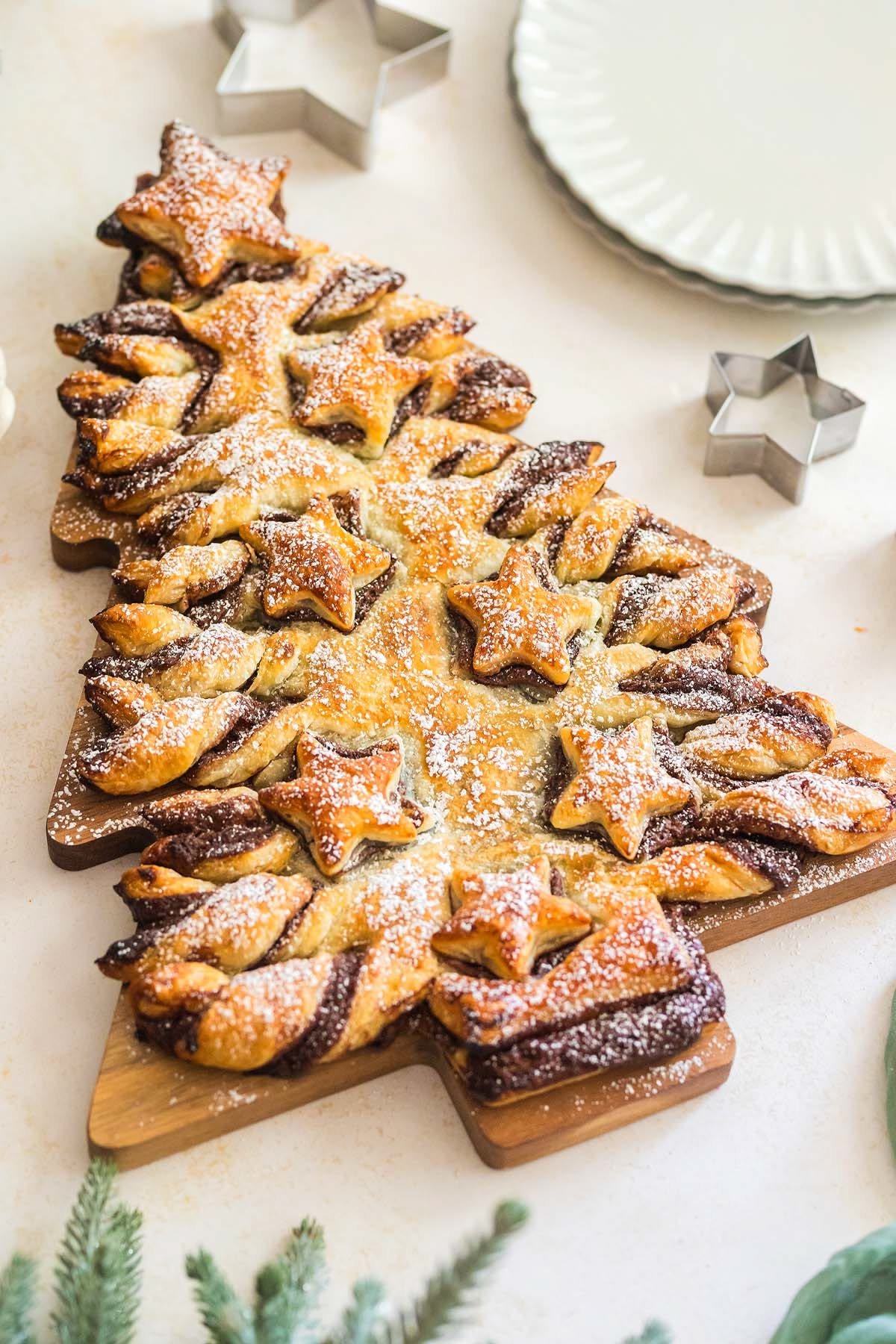 Puff pastry shaped into a Christmas tree with Nutella swirls and star cutouts