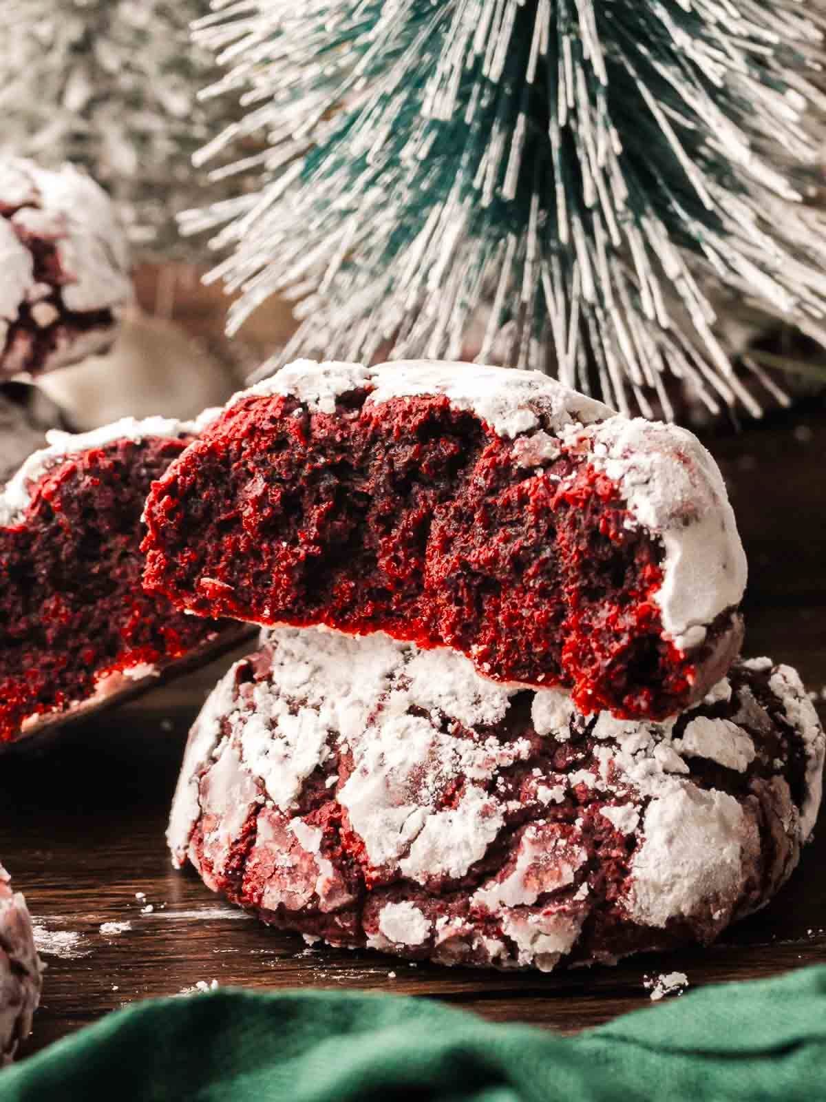 Red velvet crinkle cookies dusted with powdered sugar stacked on a plate