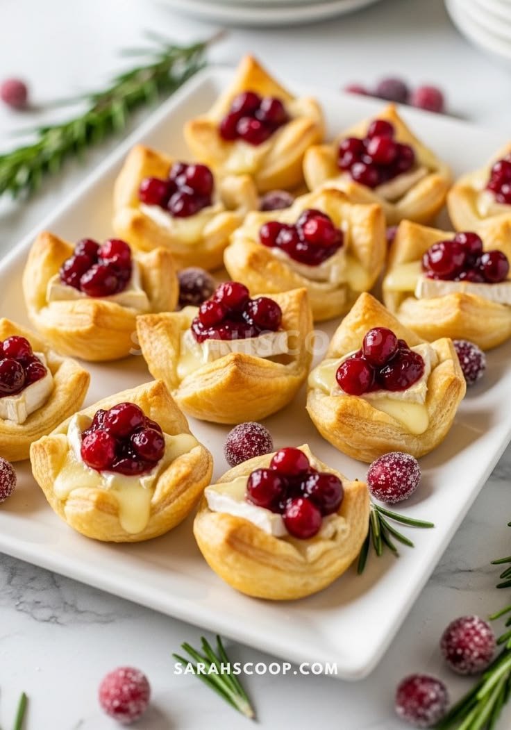 Baked brie and cranberry puff pastry cups on a platter