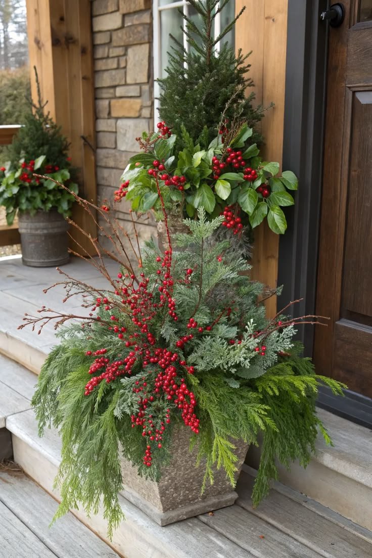 Tall narrow Christmas planter with cedar and dusty miller foliage on porch steps