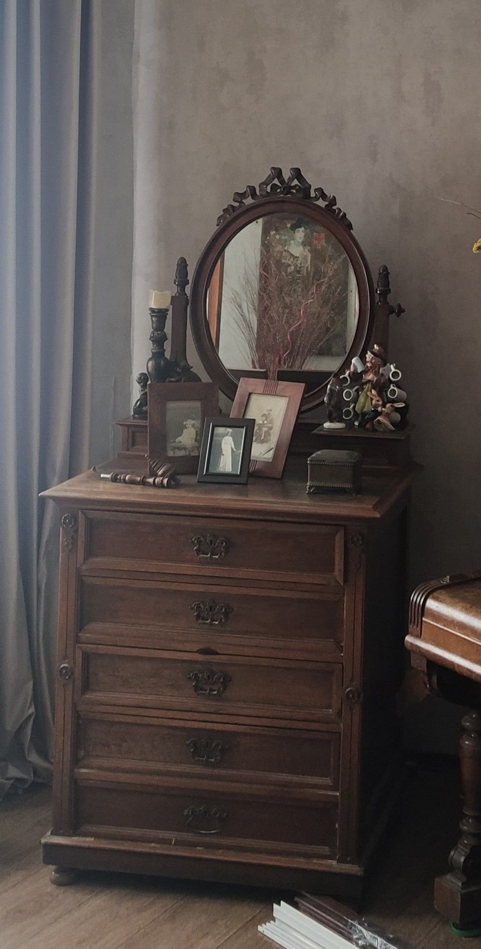 Antique wood dresser with an oval mirror in a cottagecore bedroom