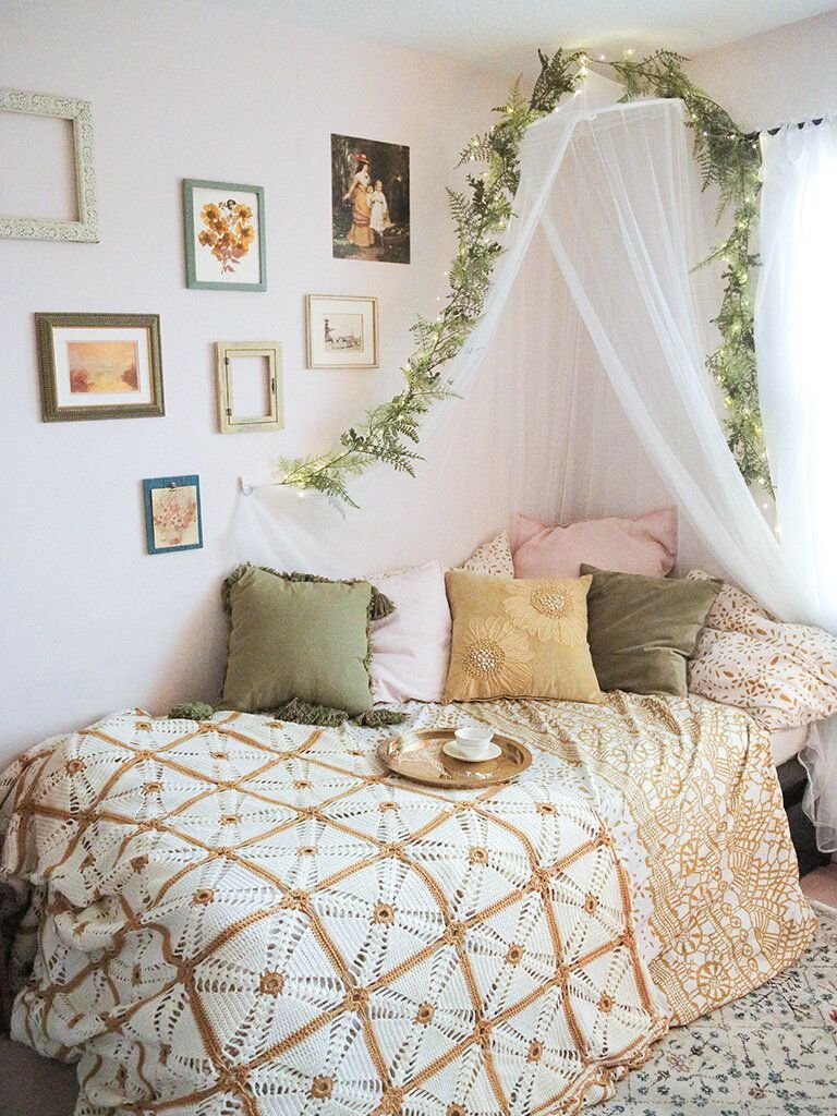Hand-crocheted lace bedspread draped over a bed in a whimsical cottagecore bedroom