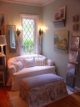 Slipcovered daybed with a ruffled ottoman tucked into a cozy cottagecore corner