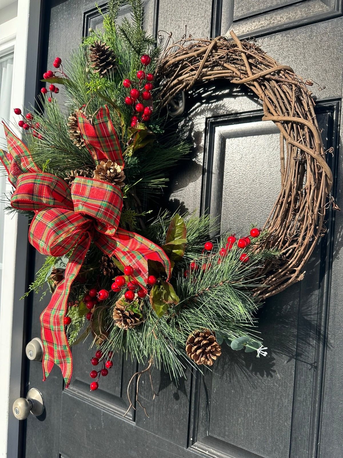 Pine wreath with pinecones and a red and green plaid bow