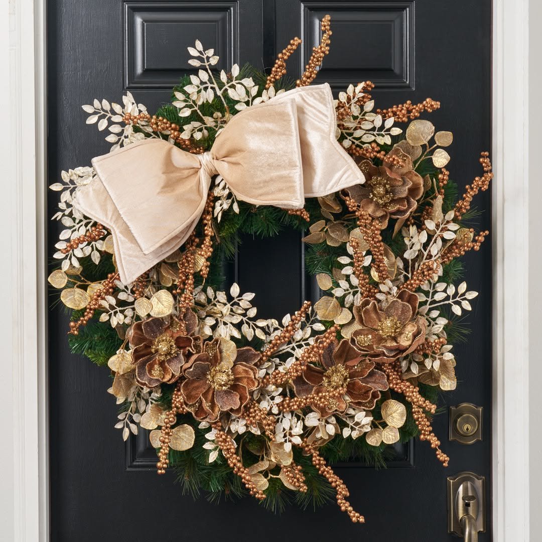 Brown velvet magnolia wreath with gold leaves on a black door