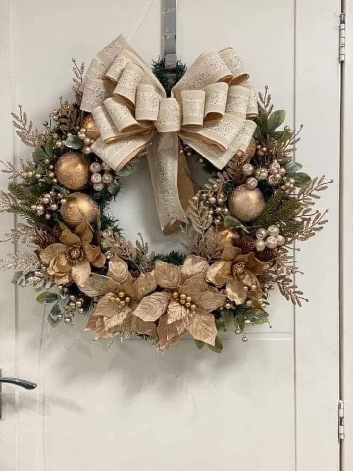 Gold poinsettia wreath with a large cream velvet bow