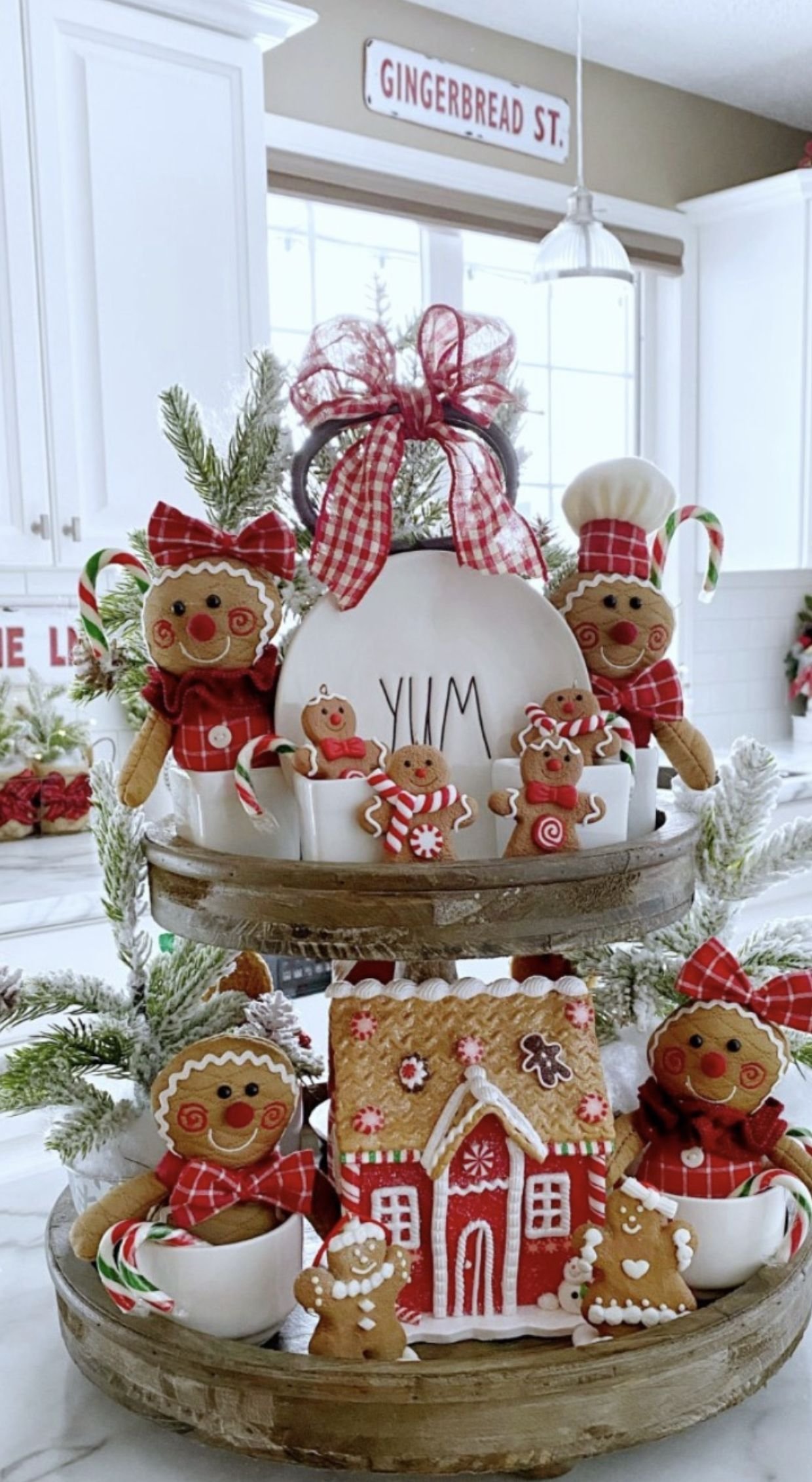 A tiered tray with plush gingerbread family figures and a Gingerbread St sign