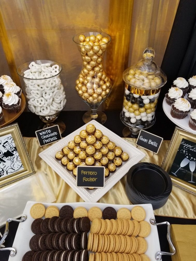 A gold and black dessert table with cupcakes, cookies, pretzels, and Ferrero Rocher chocolates