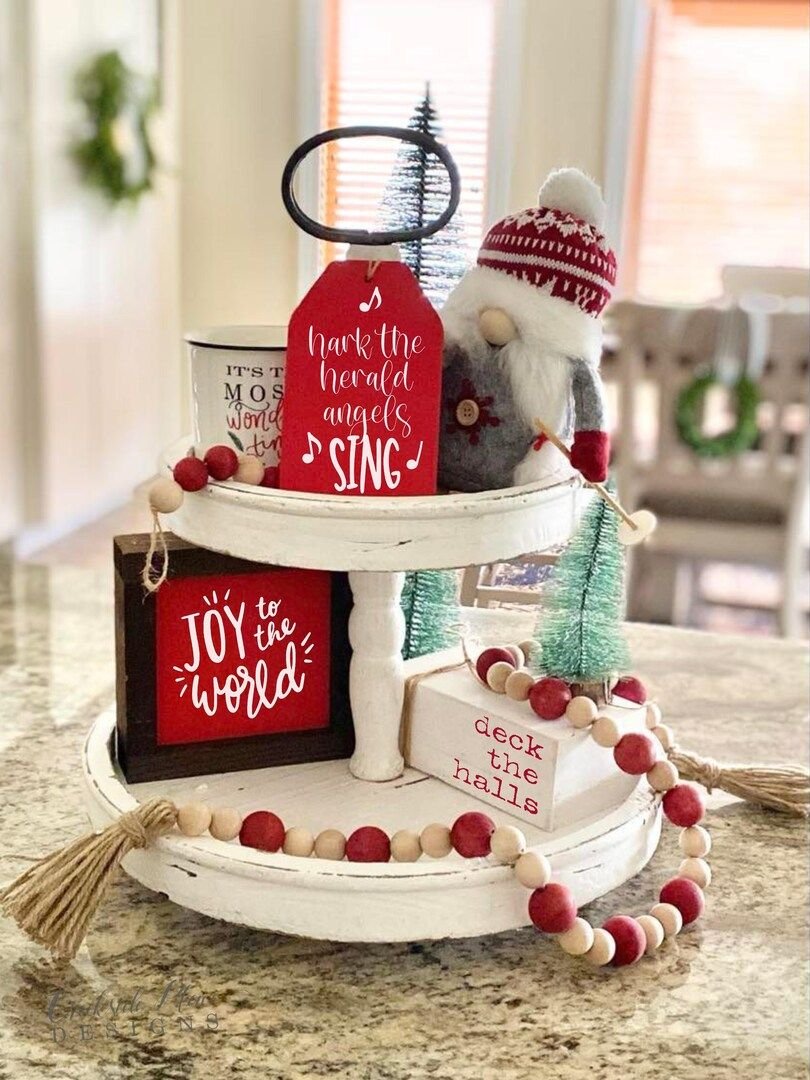 Two-tier Christmas tray with carol-themed signs, a gnome, and a wood bead garland