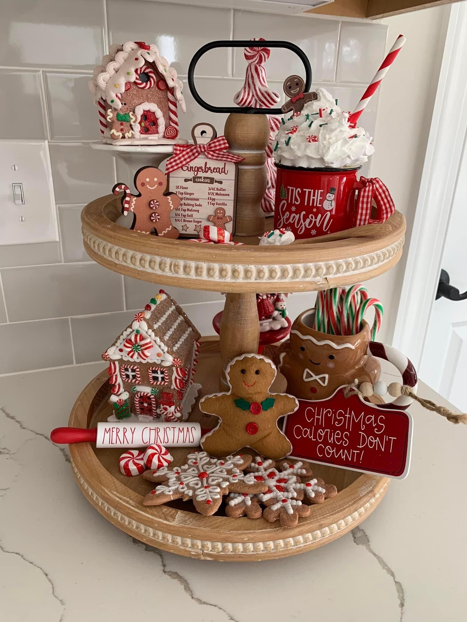 Tiered tray with a Tis the Season mug, gingerbread house, and Christmas Calories Dont Count sign
