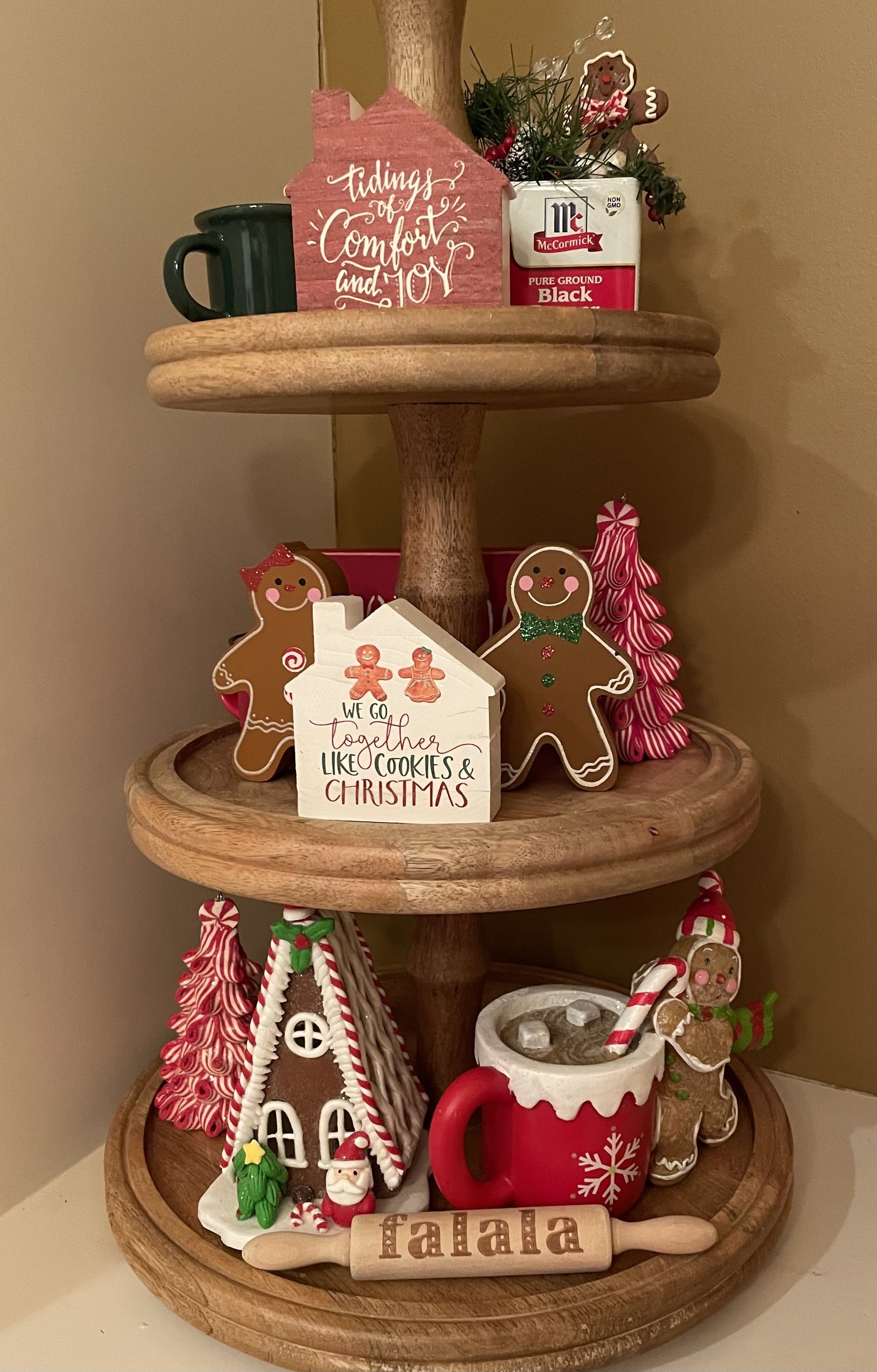 Tiered tray with a gingerbread family sign, falala rolling pin, and cocoa mug