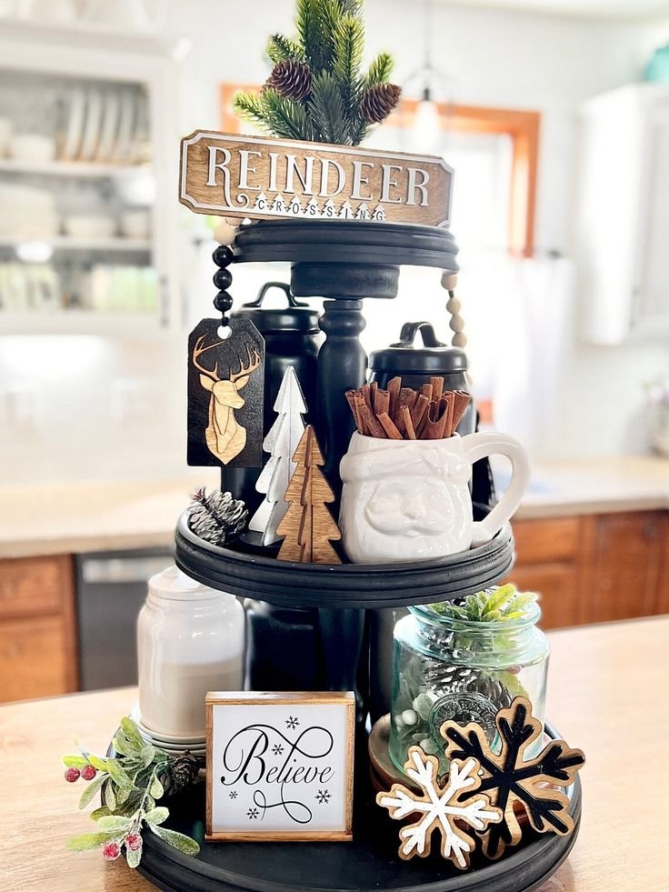 Black tiered tray with a Reindeer Crossing wood sign and cinnamon sticks
