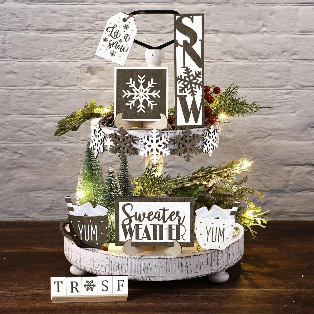Tiered tray with black and white Snow and Sweater Weather wood signs and string lights