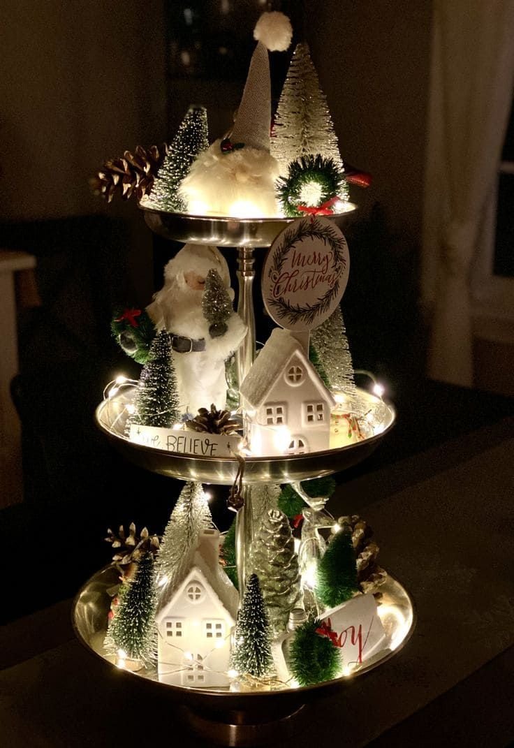 Gold mirrored tiered tray with lit white Christmas village houses