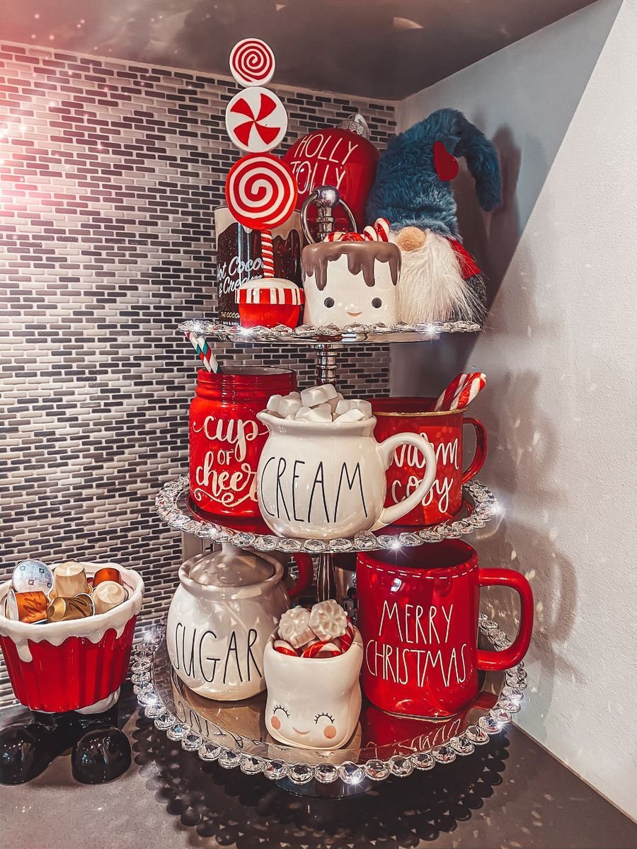 Three-tier tray with marshmallow topped mugs and a Holly Jolly sign
