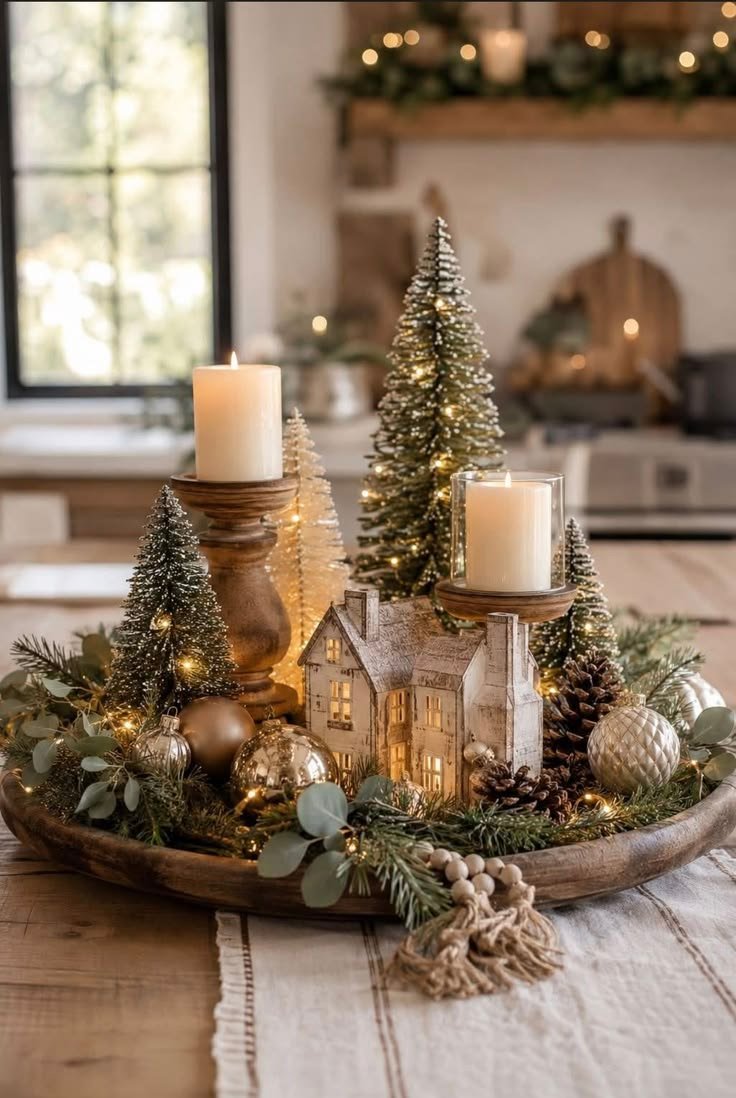 Gold tray with lit ceramic houses and gold ball ornaments