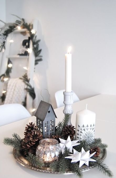 Silver tray with a candle, tin house lantern, and paper stars