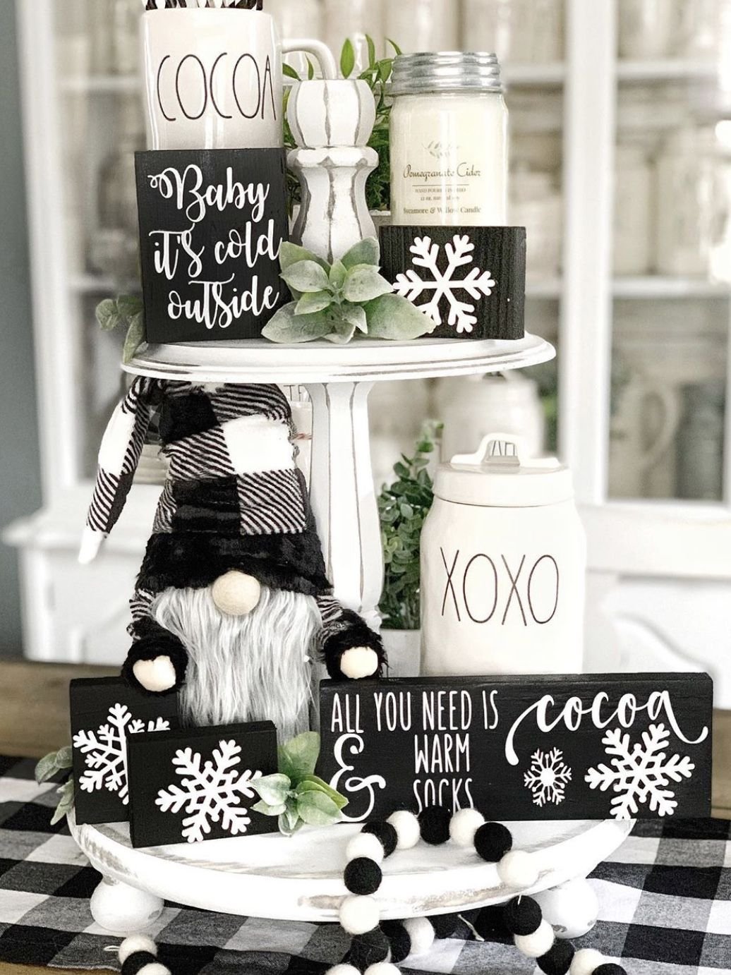Black and white tiered tray with a plush gnome and snowflake sign