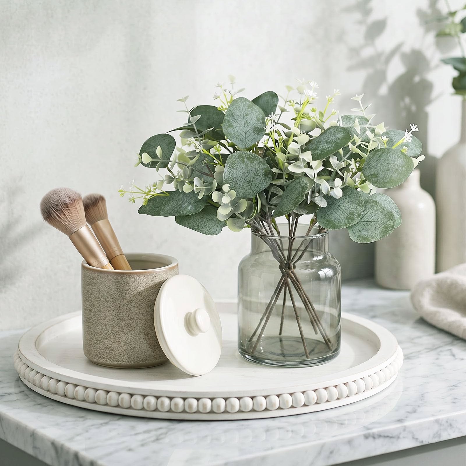 Vanity tray with eucalyptus stems and a lidded ceramic jar